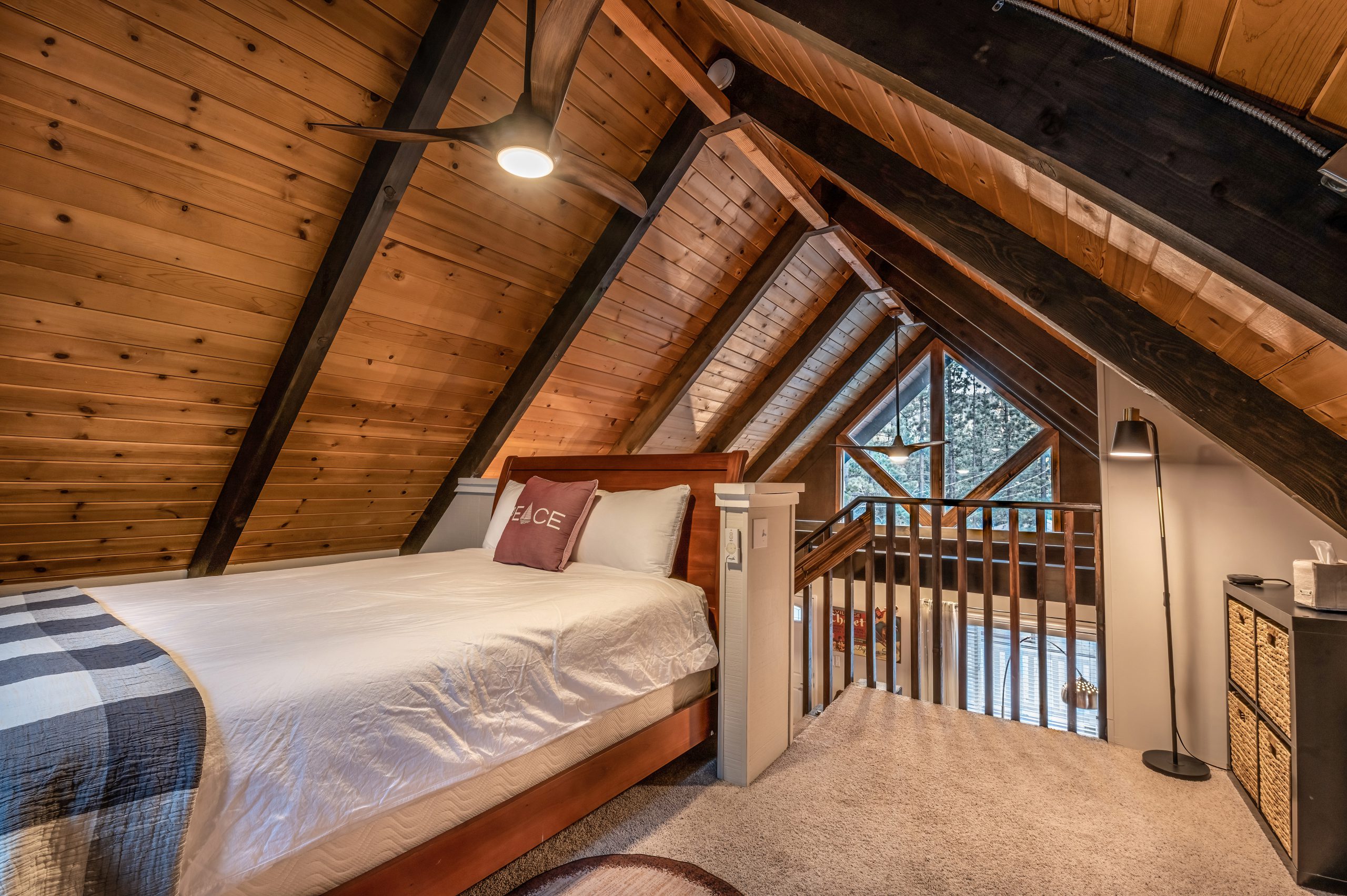 A different angle from the small, but cozy loft. Queen size bed and ceiling fan with gorgeous view out the window compliment this special area.